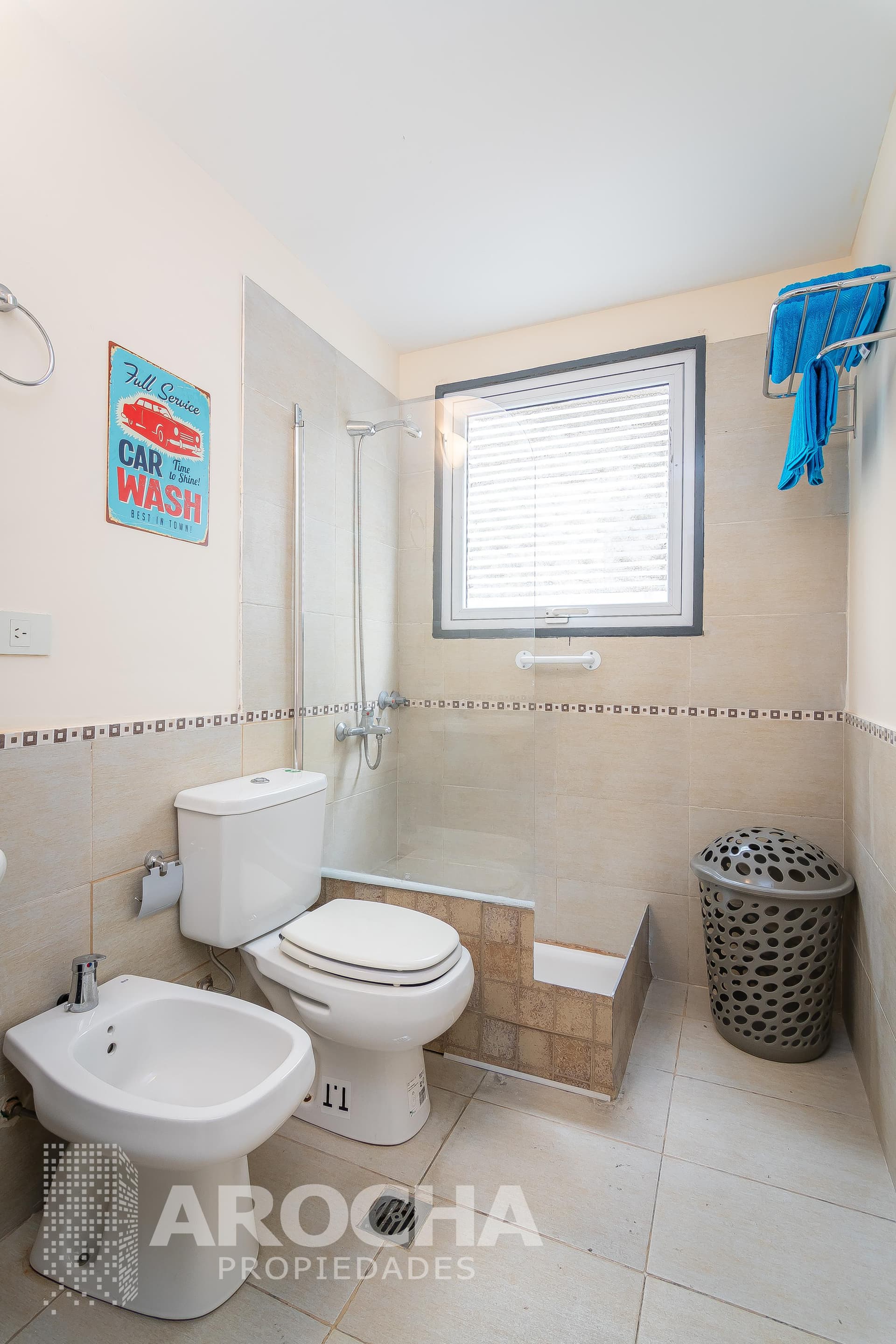 Baño completo con ducha, inodoro, bidet y ventana.
