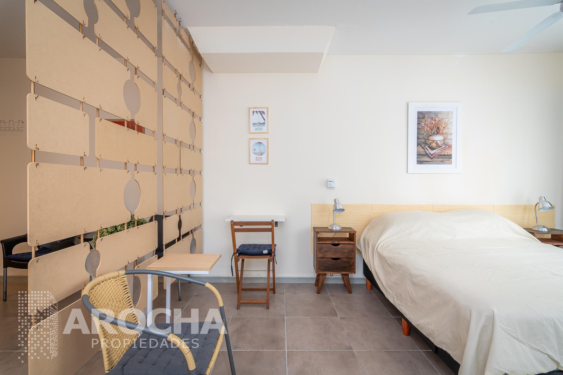 Dormitorio con cama doble, mesas de luz y separador de ambientes moderno.