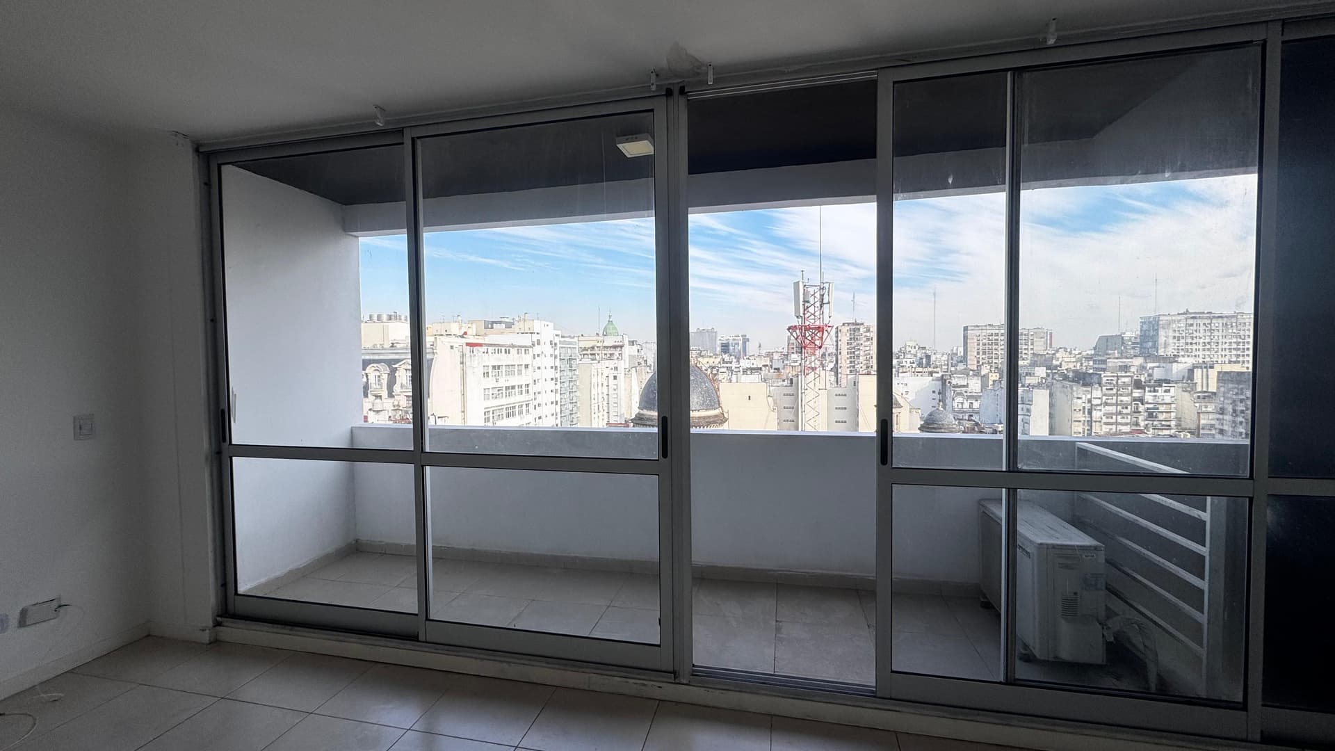 Balcón amplio con vista panorámica a la ciudad y edificios.