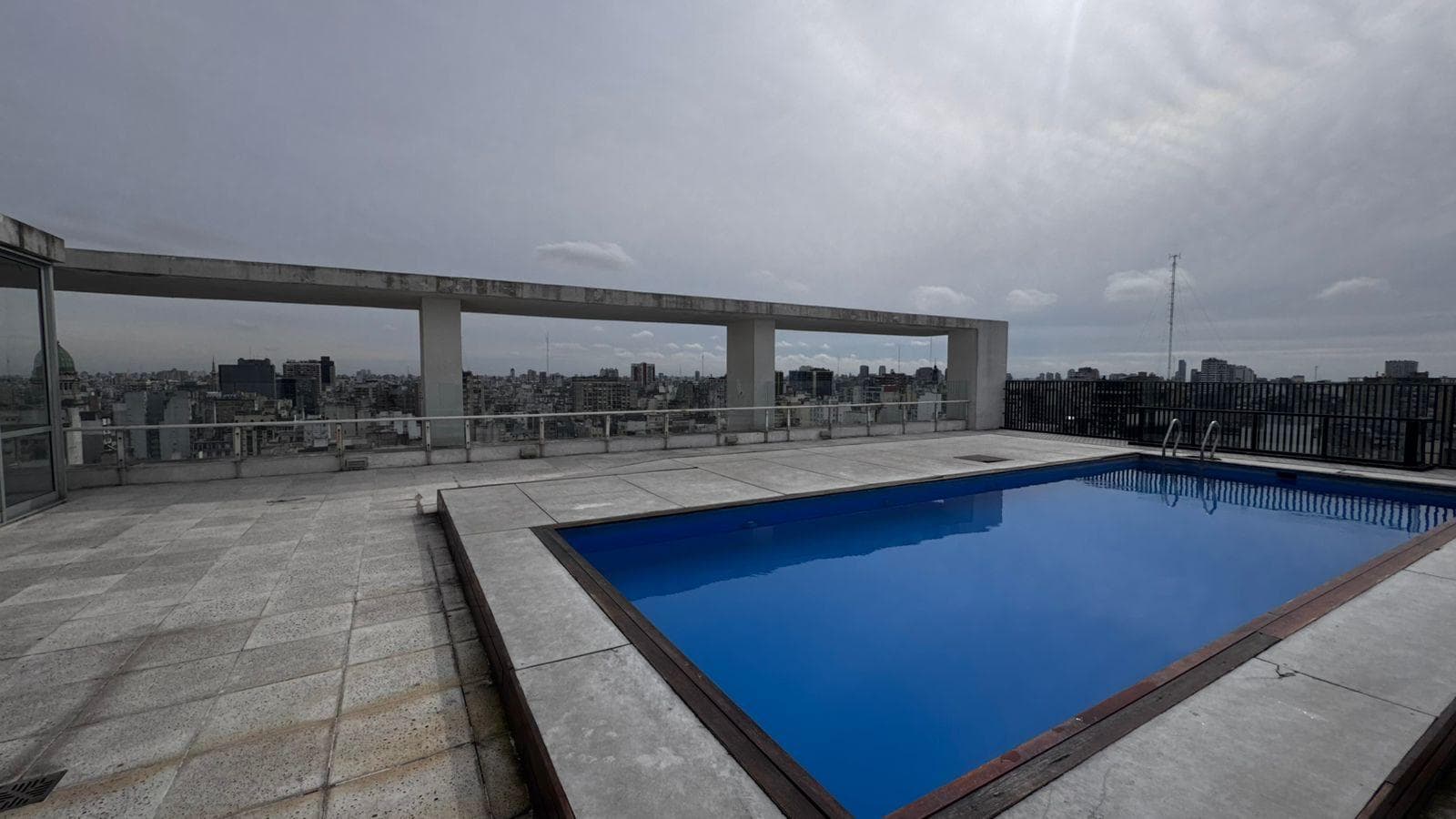 Pileta en la terraza del edificio con vista a la ciudad.