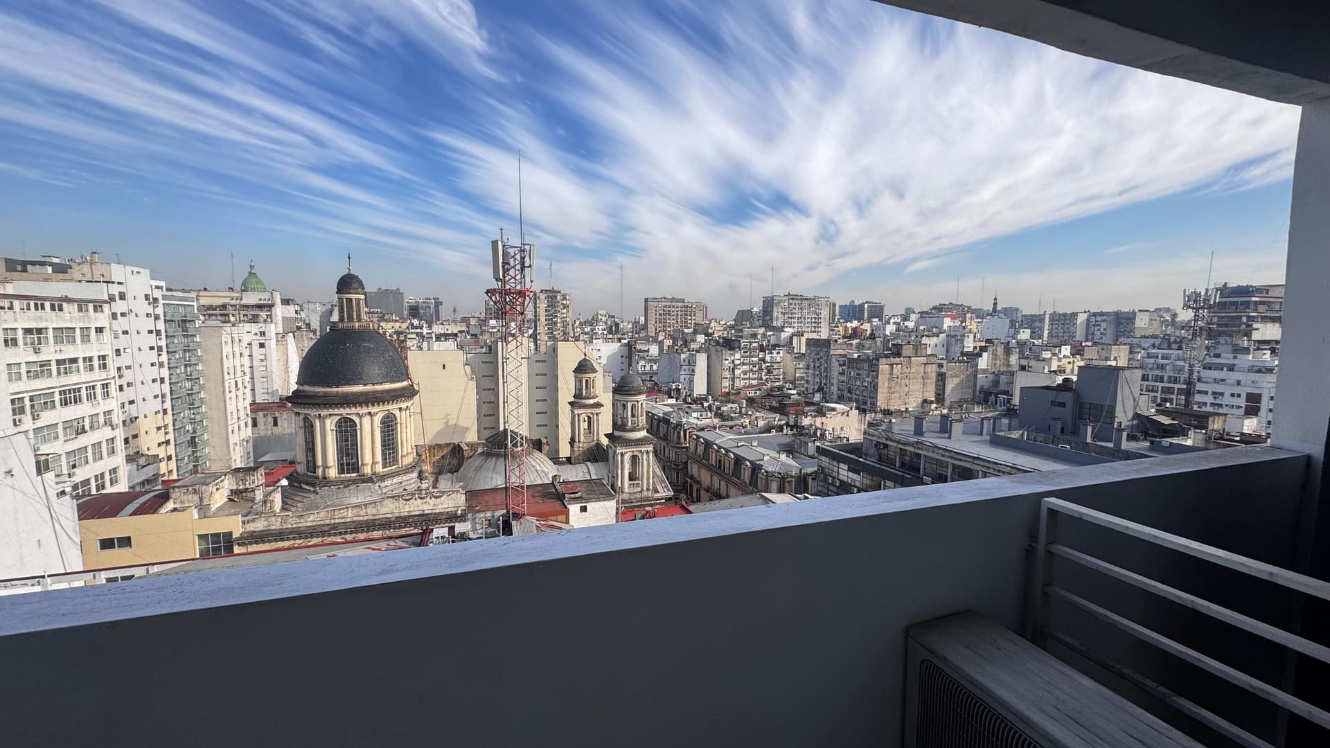 Vista panorámica de la ciudad desde el balcón con cúpulas y edificios.