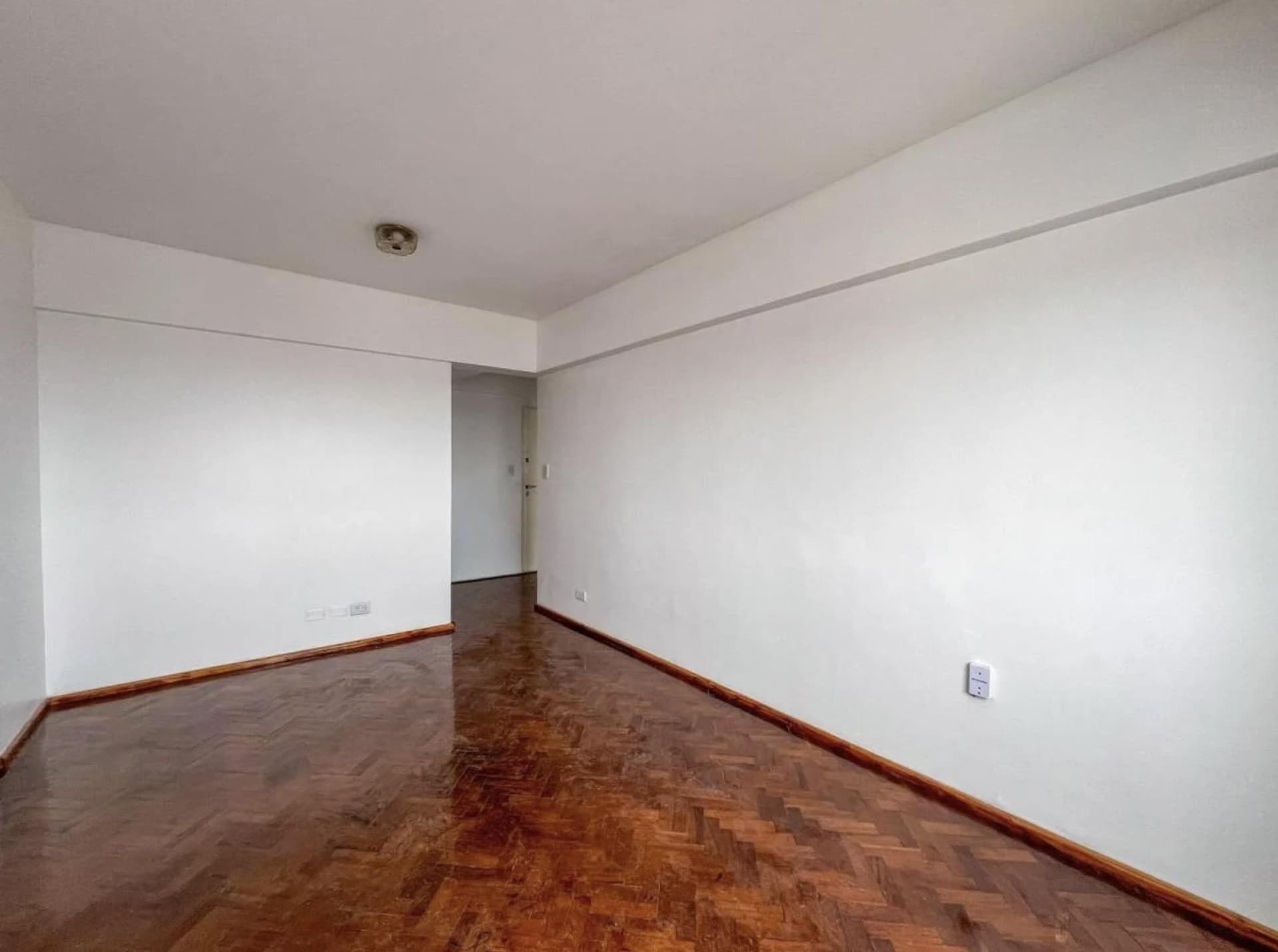 Living comedor vacío con piso de parquet