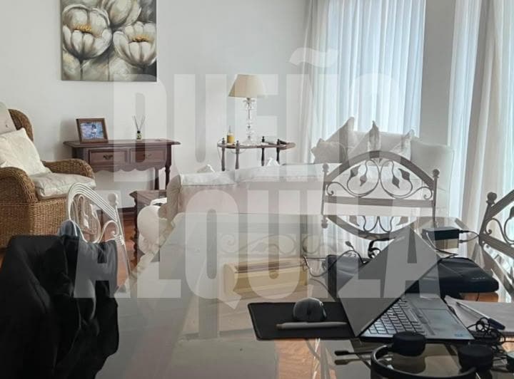 Sala de estar con sillones, mesa de centro y cuadro decorativo.