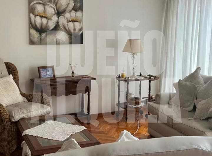 Living con sillones cómodos, mesas auxiliares y lámpara de mesa.