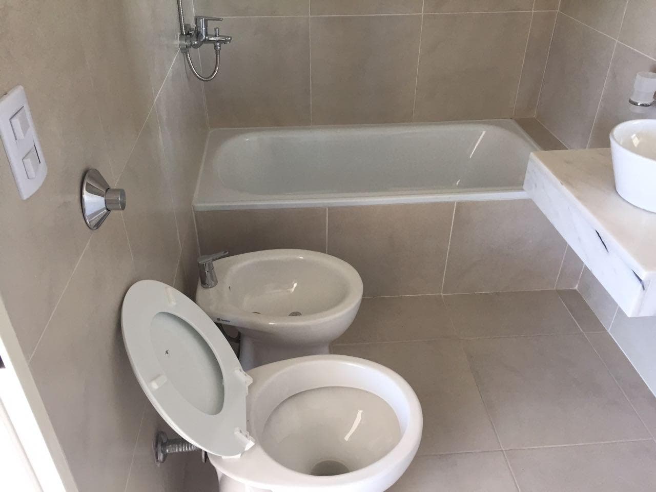 Baño con bañera, inodoro, bidet y vanitory.
