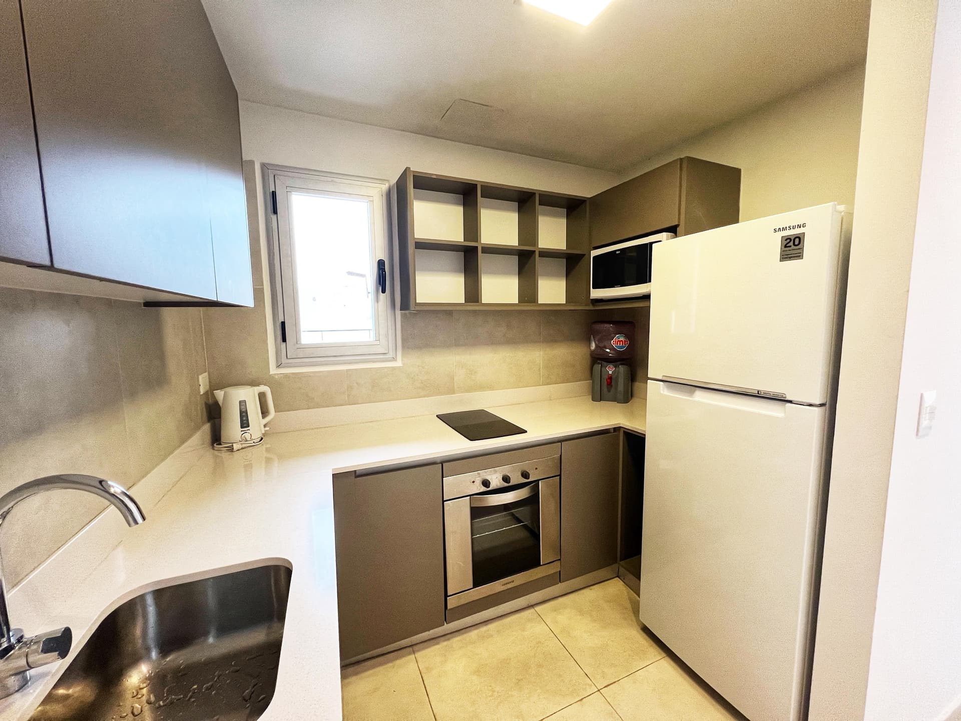 Cocina equipada con heladera, microondas, anafe, horno y alacenas.