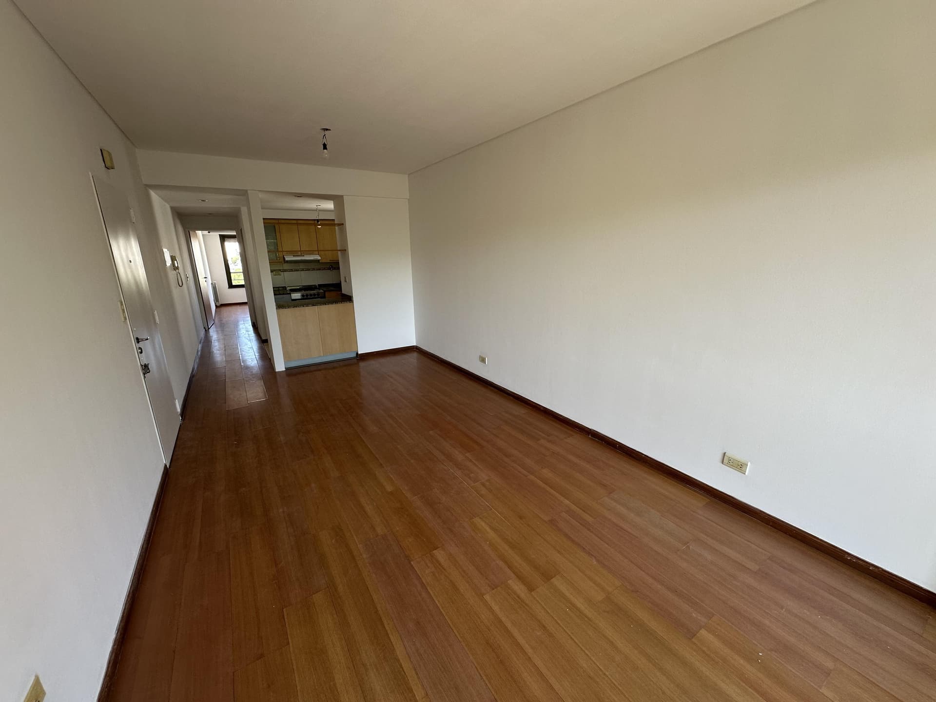 Pasillo con piso de madera que conecta cocina y otros ambientes.