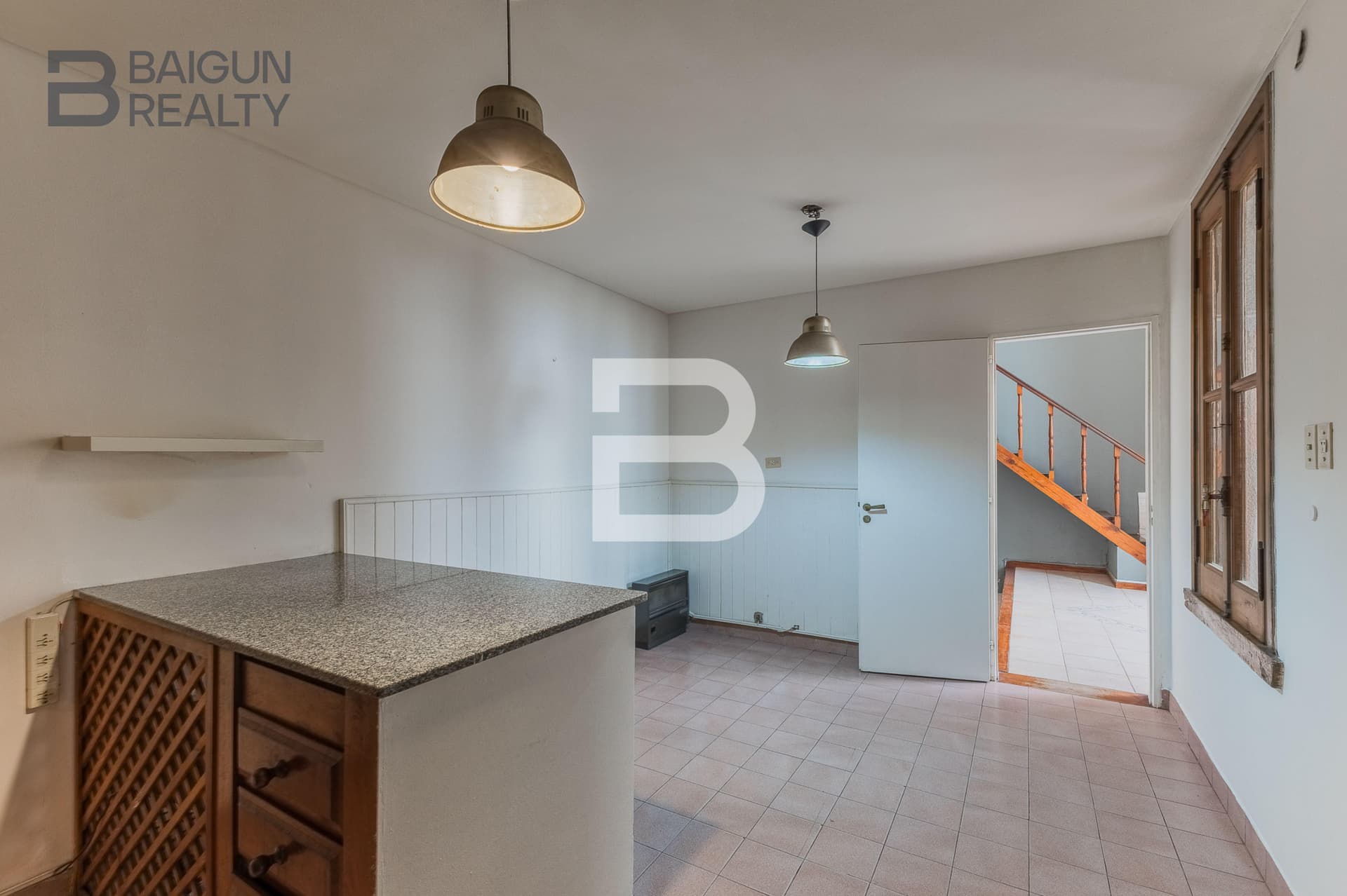 Cocina con barra, lámparas y acceso a otro ambiente.