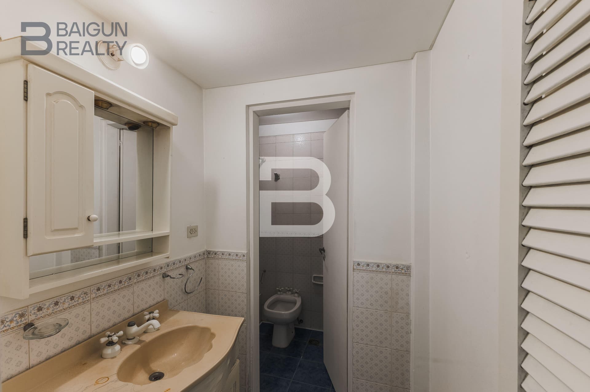 Baño con vanitory, espejo y bidet.