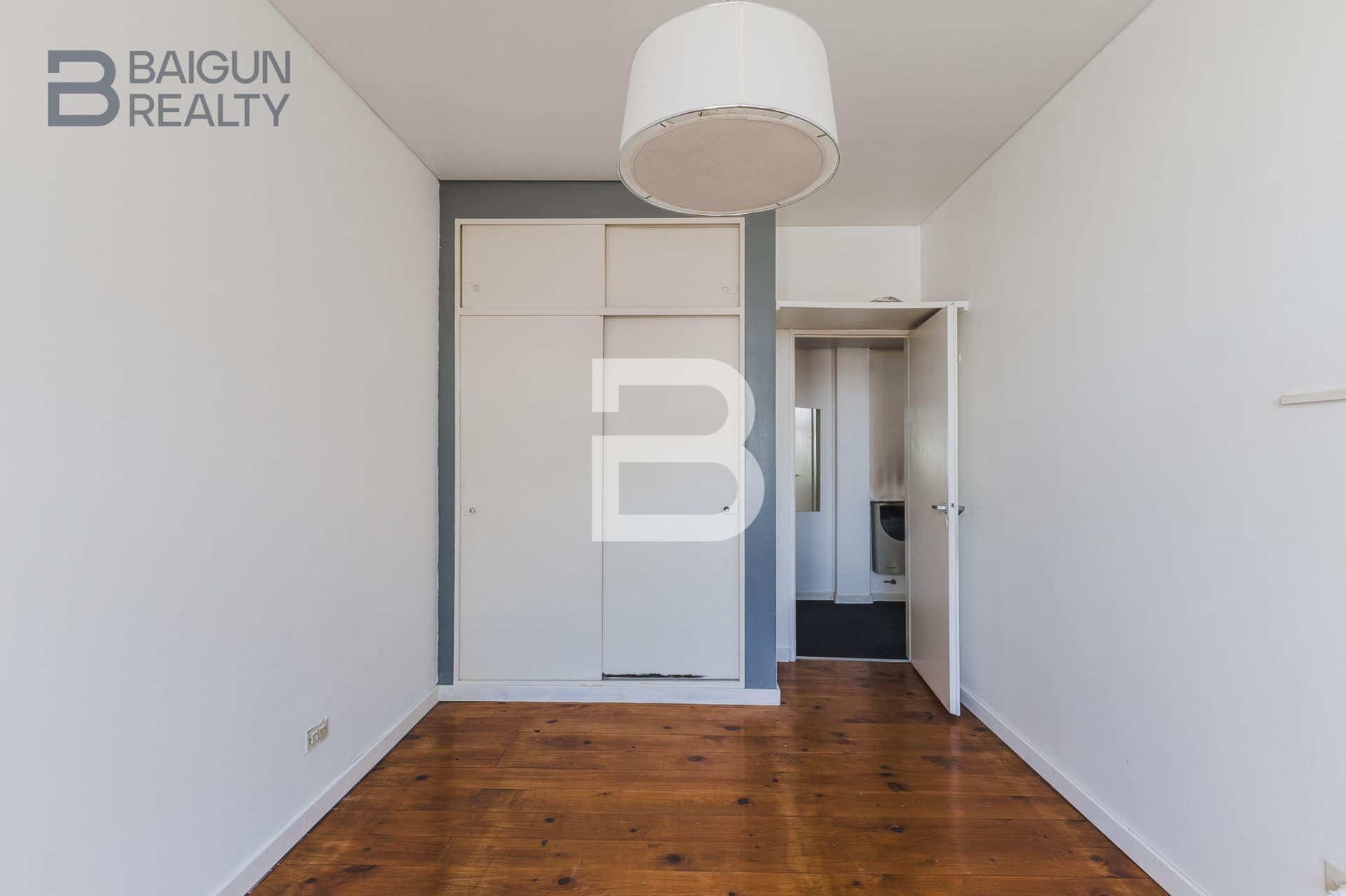 Dormitorio vacío con placard y puerta abierta.