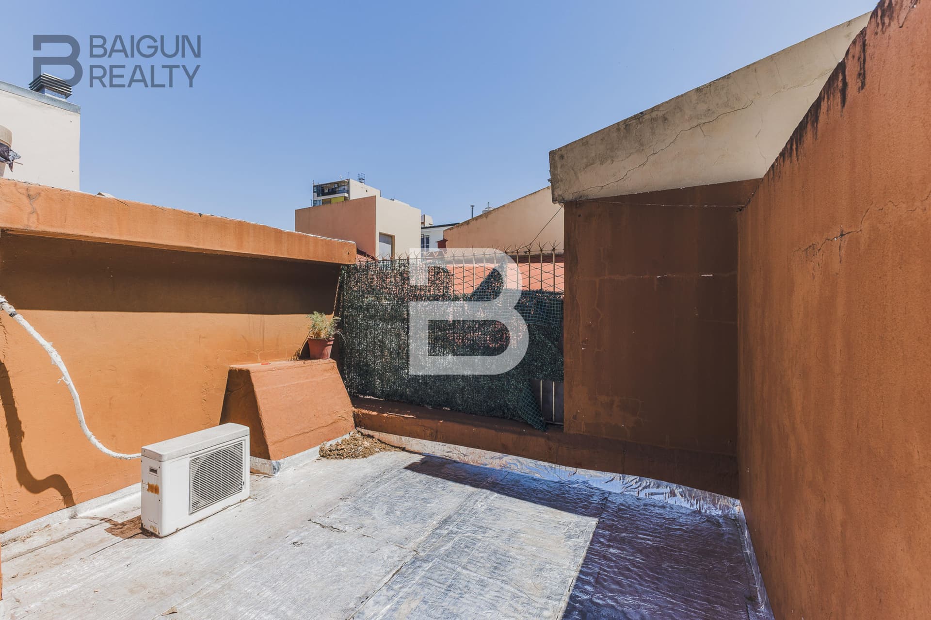 Terraza exterior con paredes bajas y unidad de aire.