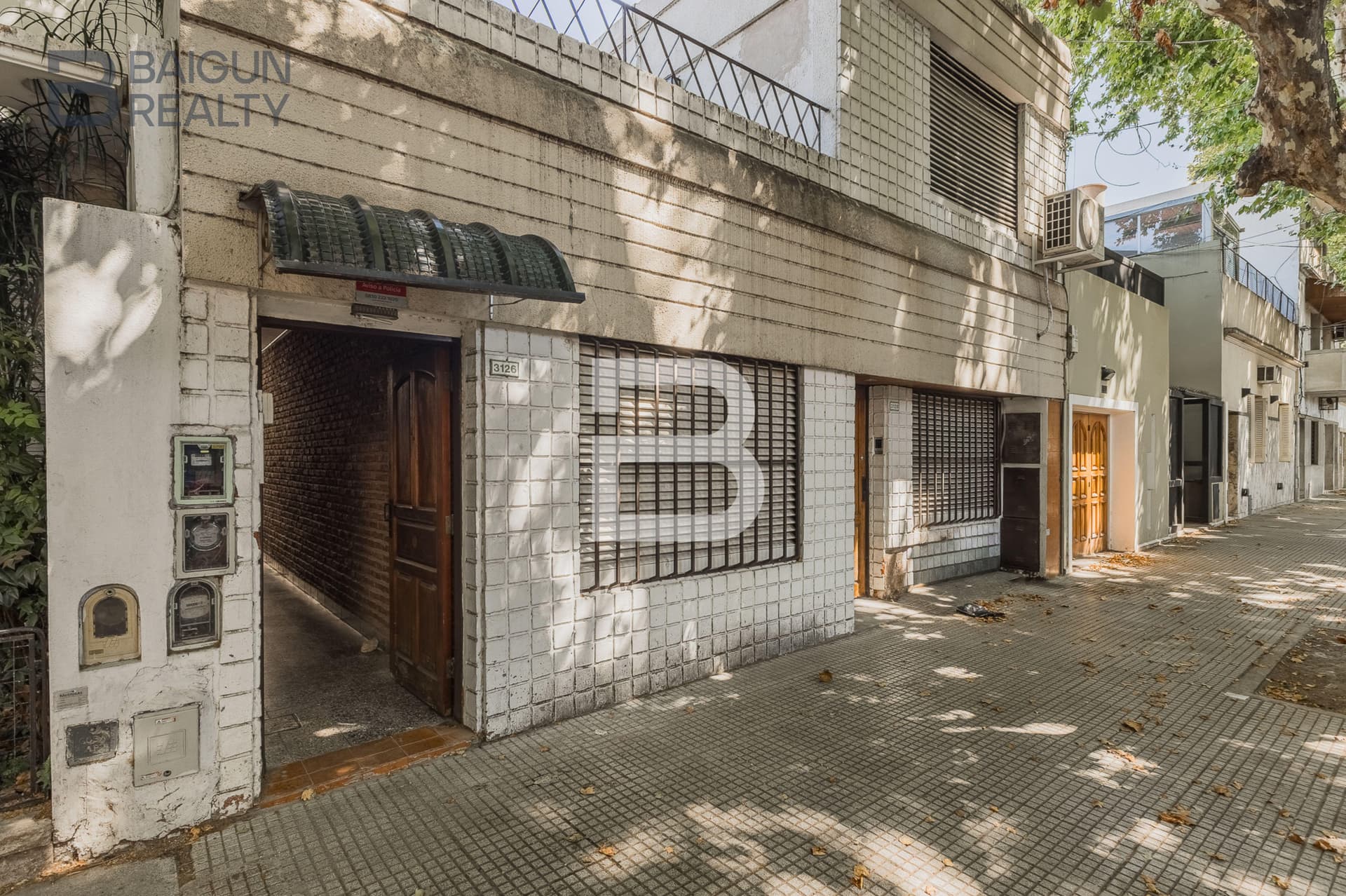 Fachada del edificio con entrada y ventanas en la calle.
