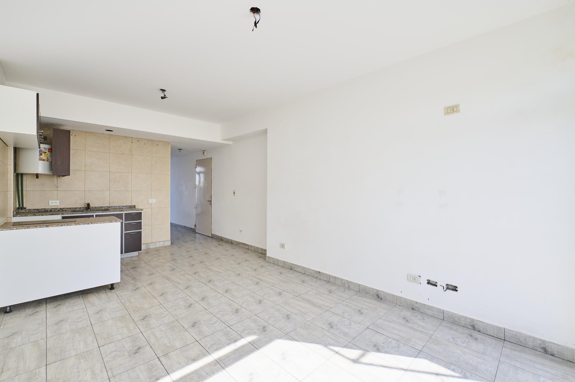 Living comedor con cocina integrada, pasillo de entrada y ambiente amplio.