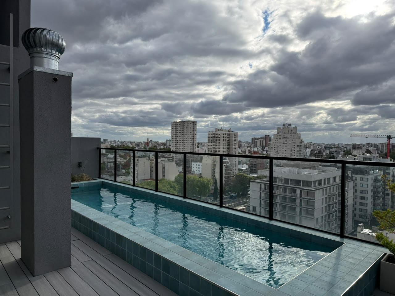 Pileta de natación en la terraza de un edificio con vistas a la ciudad.