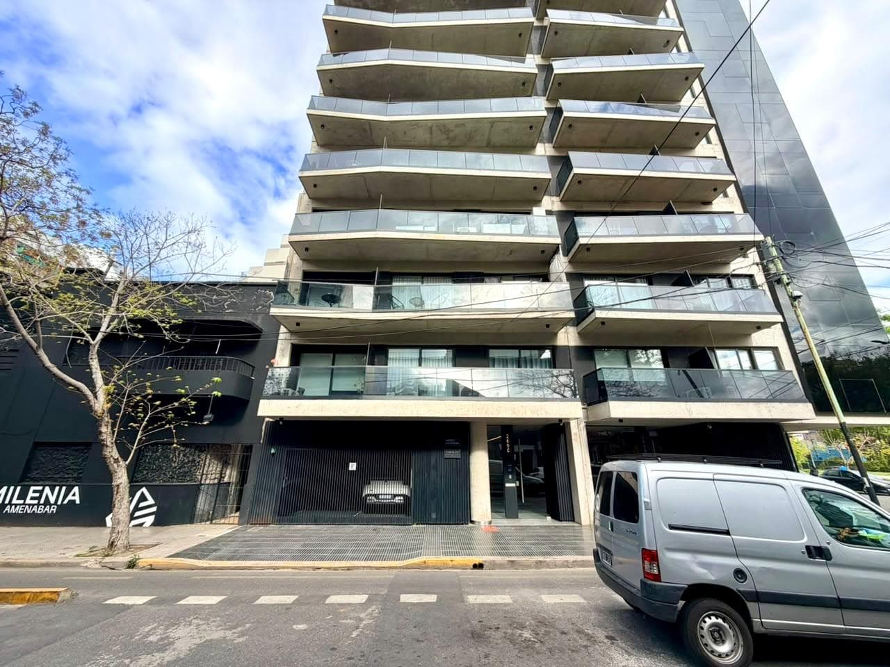 Fachada moderna de un edificio de departamentos visto desde la calle.