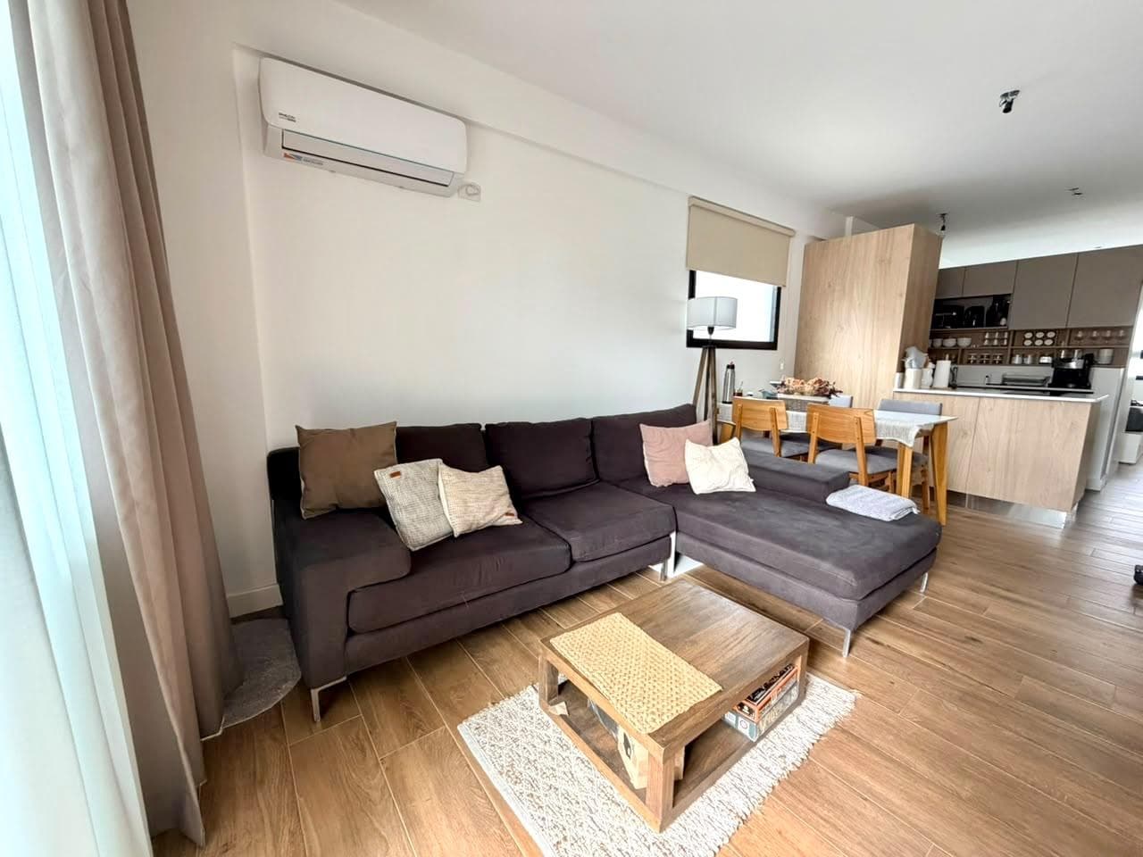 Living con sillón, comedor y cocina integrada en espacio abierto.