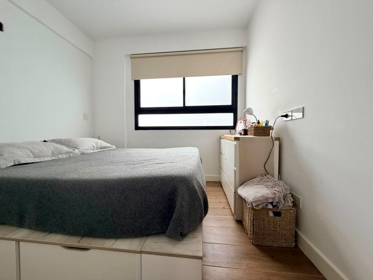 Dormitorio con cama de dos plazas, cómoda con cajones y ventana.