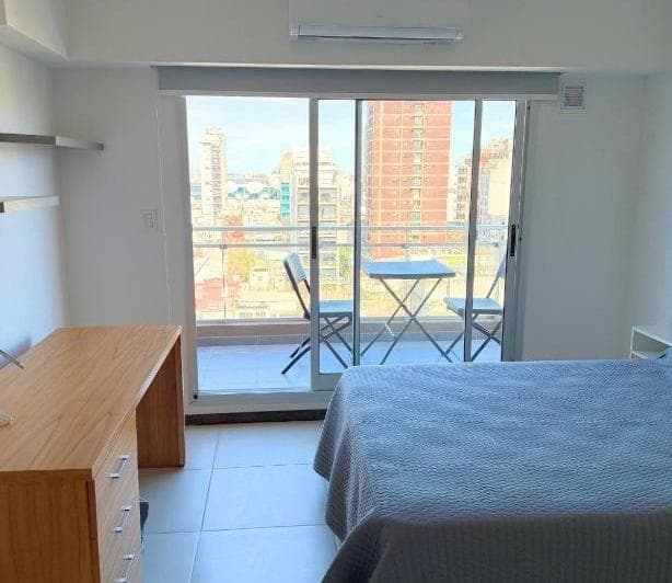 Balcón con mesa y sillas con vista a la ciudad.