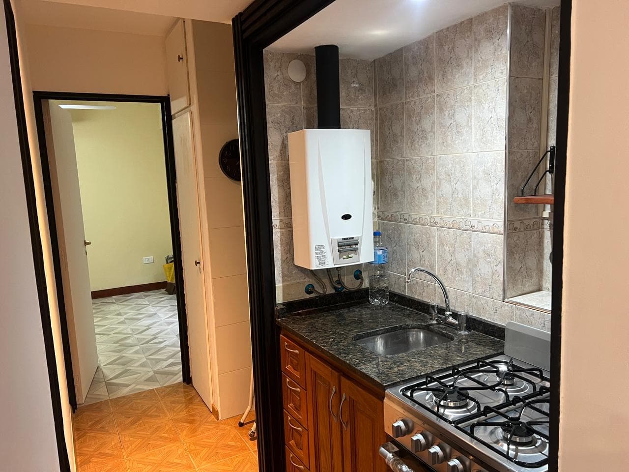 Cocina integrada con mesada, anafe, bacha y termotanque.