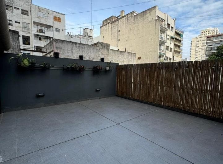 Patio exterior con cerco de cañas y edificios circundantes
