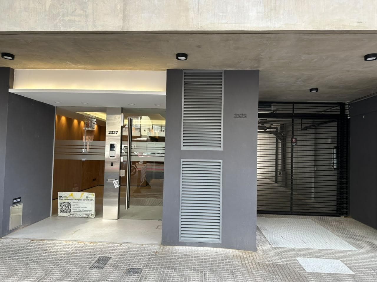 Fachada del edificio con entrada principal y portón de cochera.