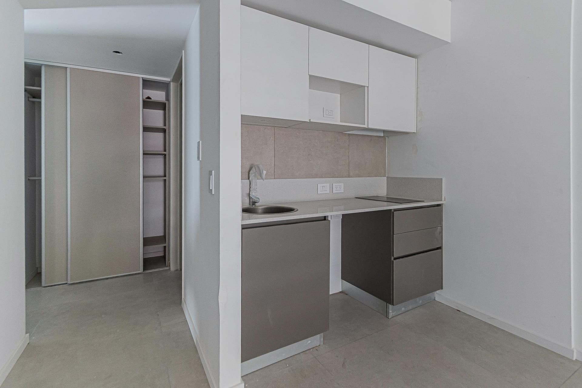 Cocina con mesada, bacha, anafe, alacenas y armario empotrado.