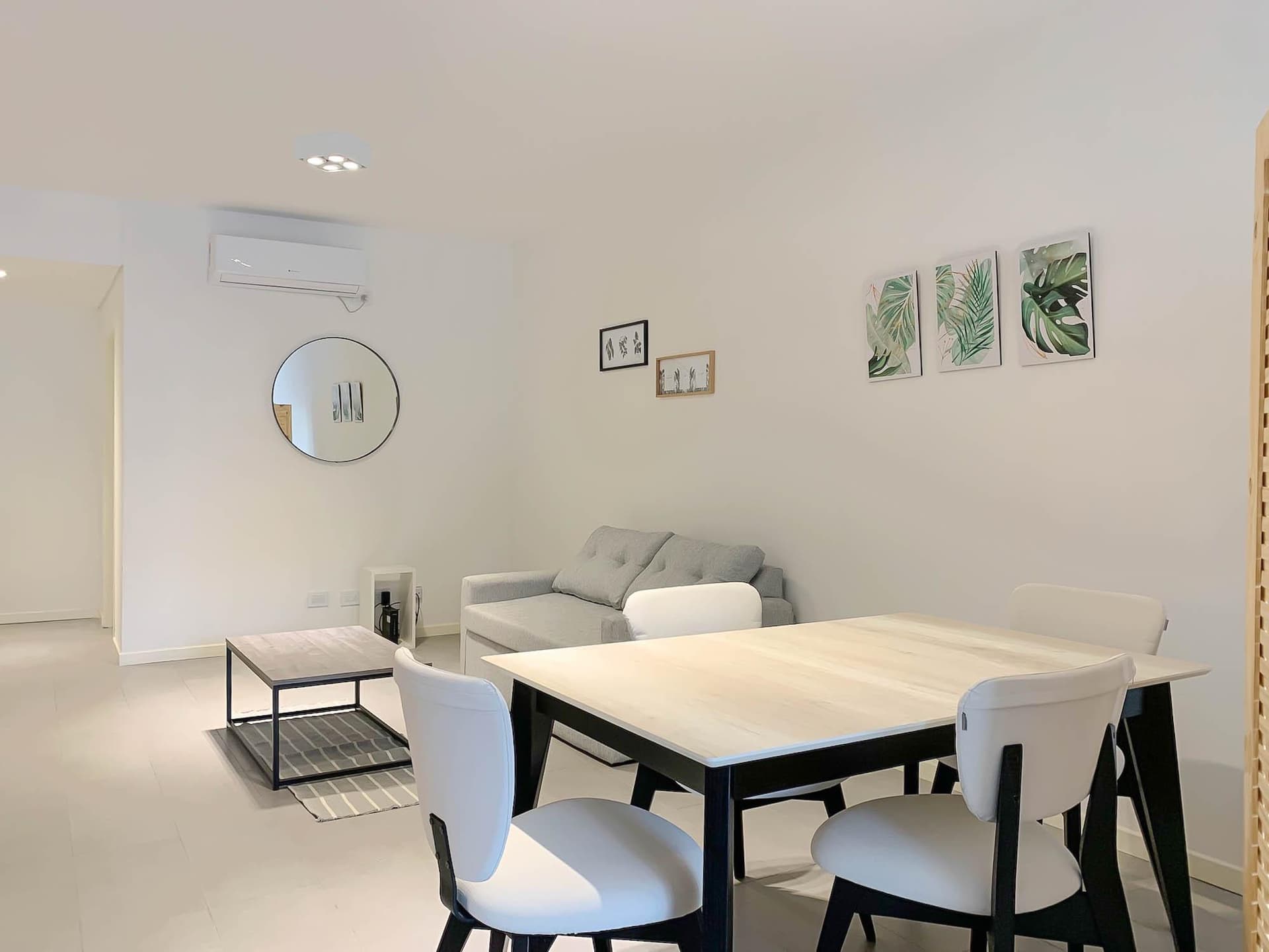 Living con sofá, mesa de centro y mesa de comedor.
