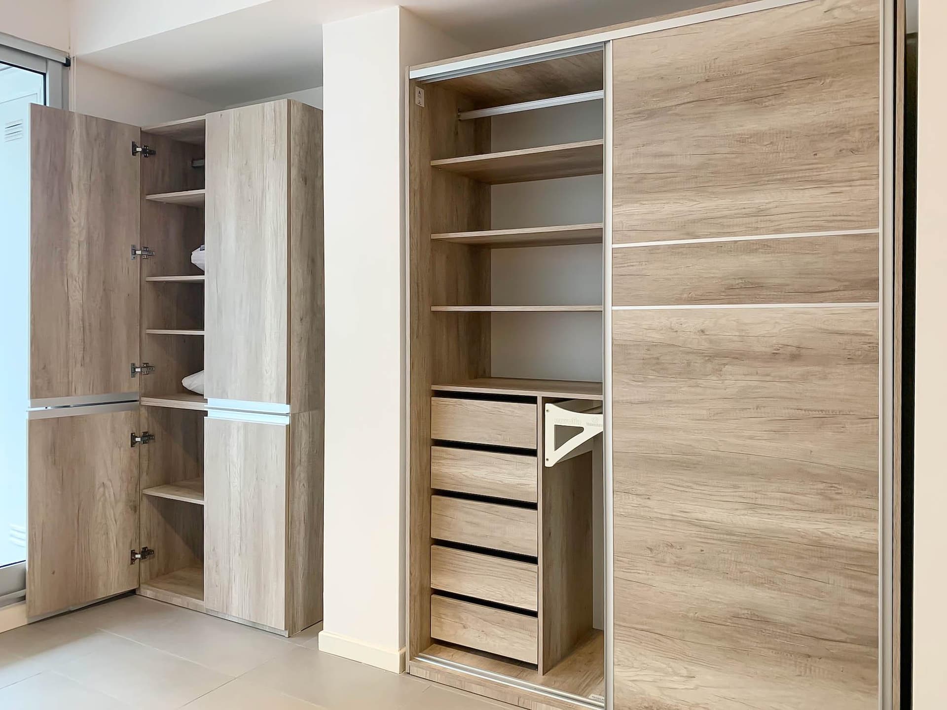Placard abierto con estantes y cajones en dormitorio.