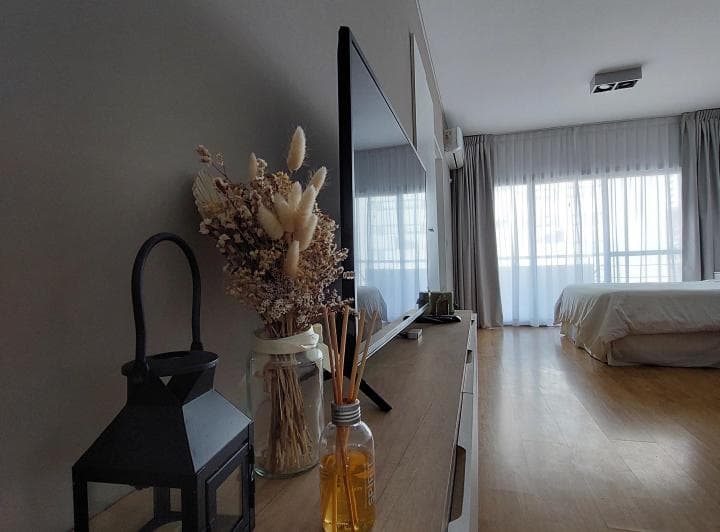 Dormitorio, vista de cerca de la televisión y decoración en el mueble.
