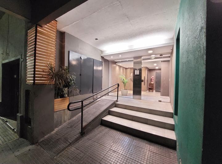 Entrada al edificio con rampa y escaleras, acceso al hall principal.