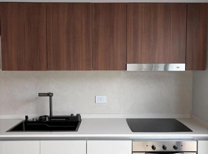 Detalle de mesada de cocina con bacha negra, grifo moderno y anafe.