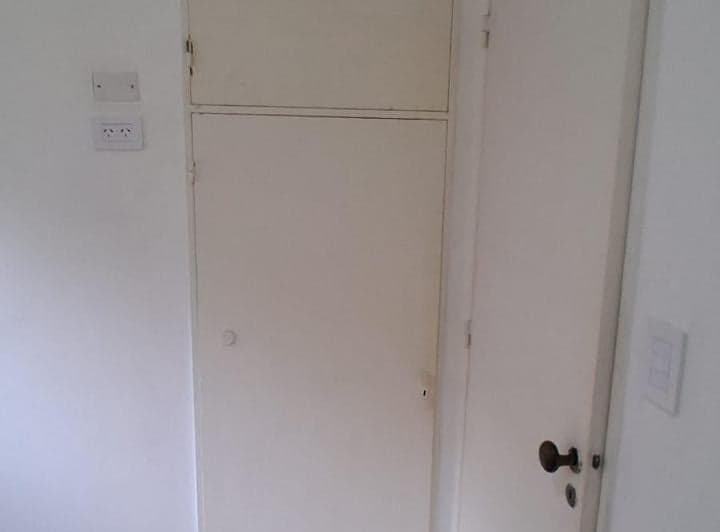 Placard y puerta en pasillo de pared blanca.
