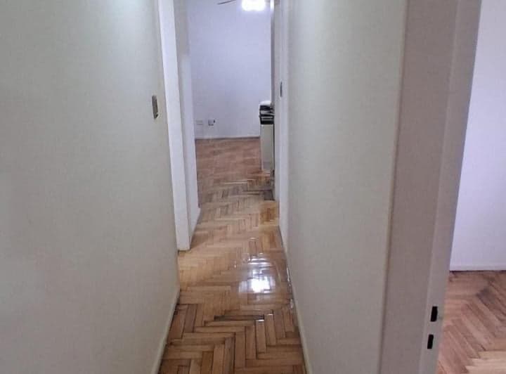 Pasillo con piso de parquet y puertas a distintas habitaciones.