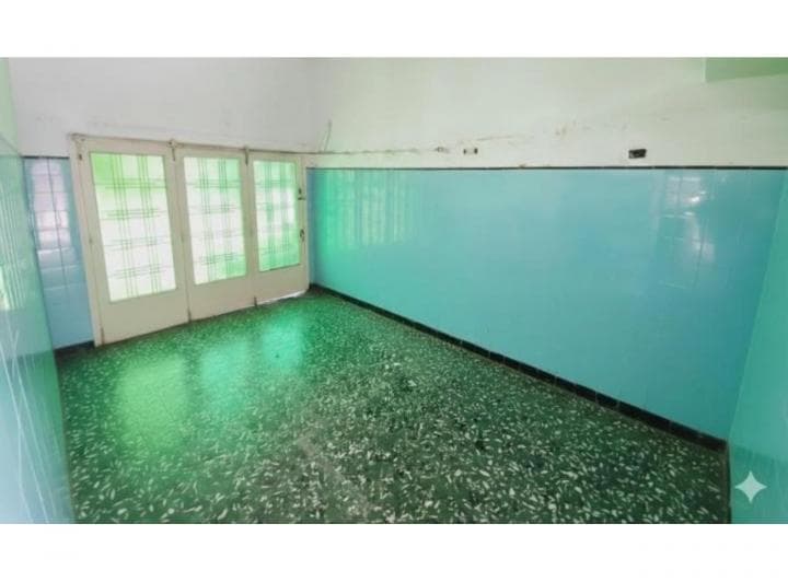 Living vacío con piso de granito verde y azulejos celestes.