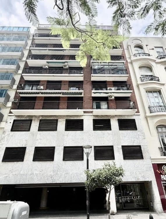 Fachada de edificio con balcones, ventanas y entrada principal.
