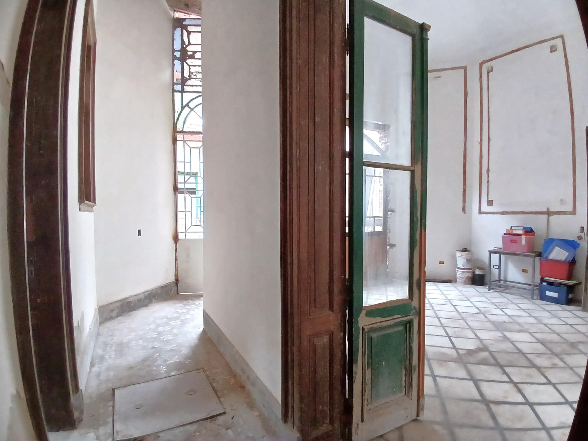 Pasillo de distribución con puertas de madera y vidrio.