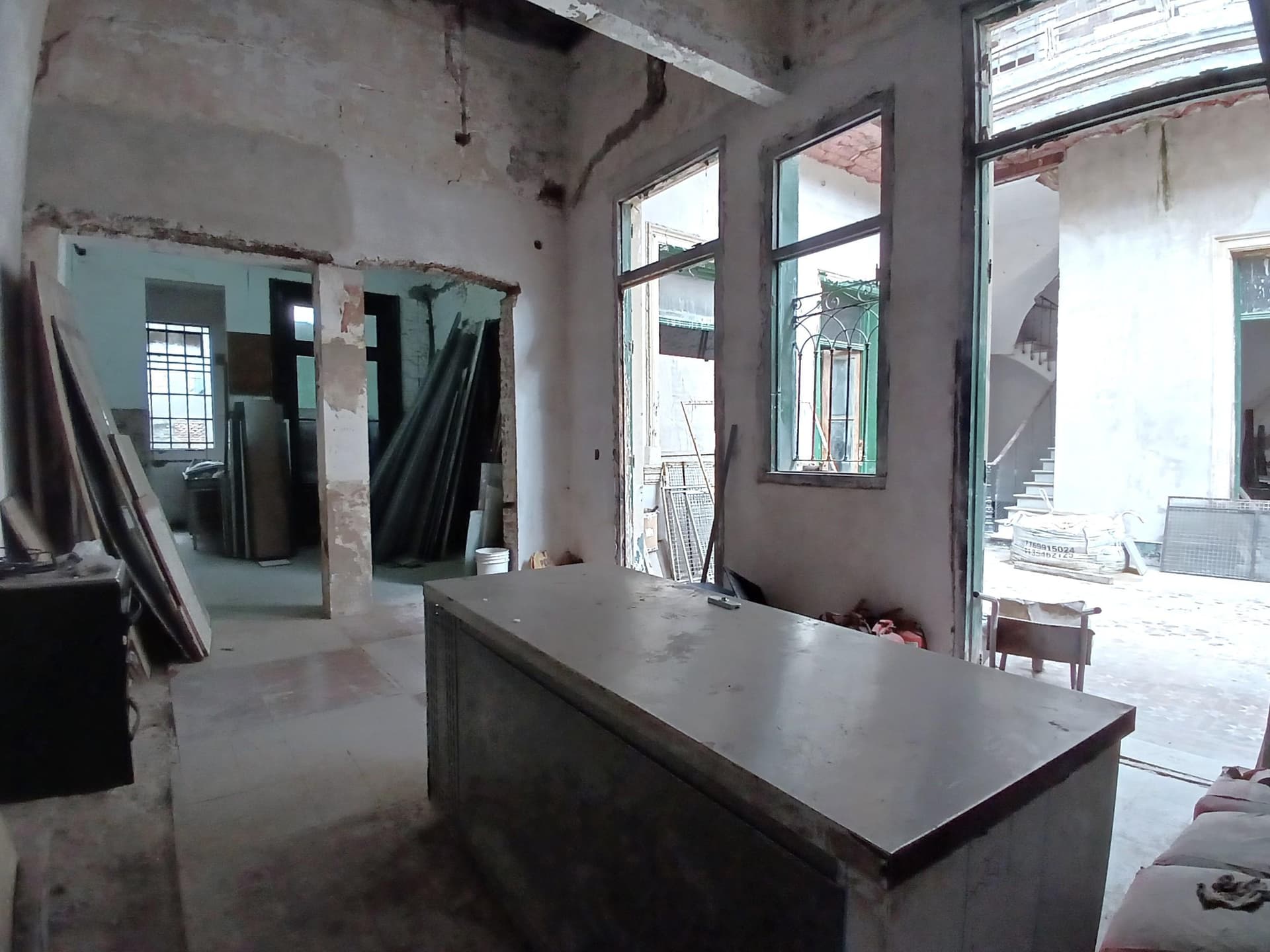 Cocina en refacción con mesada de acero y paredes sin revocar.