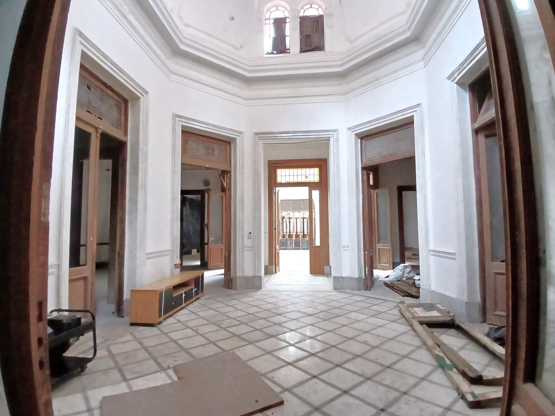 Hall de entrada octogonal con baldosas y un vanitory.