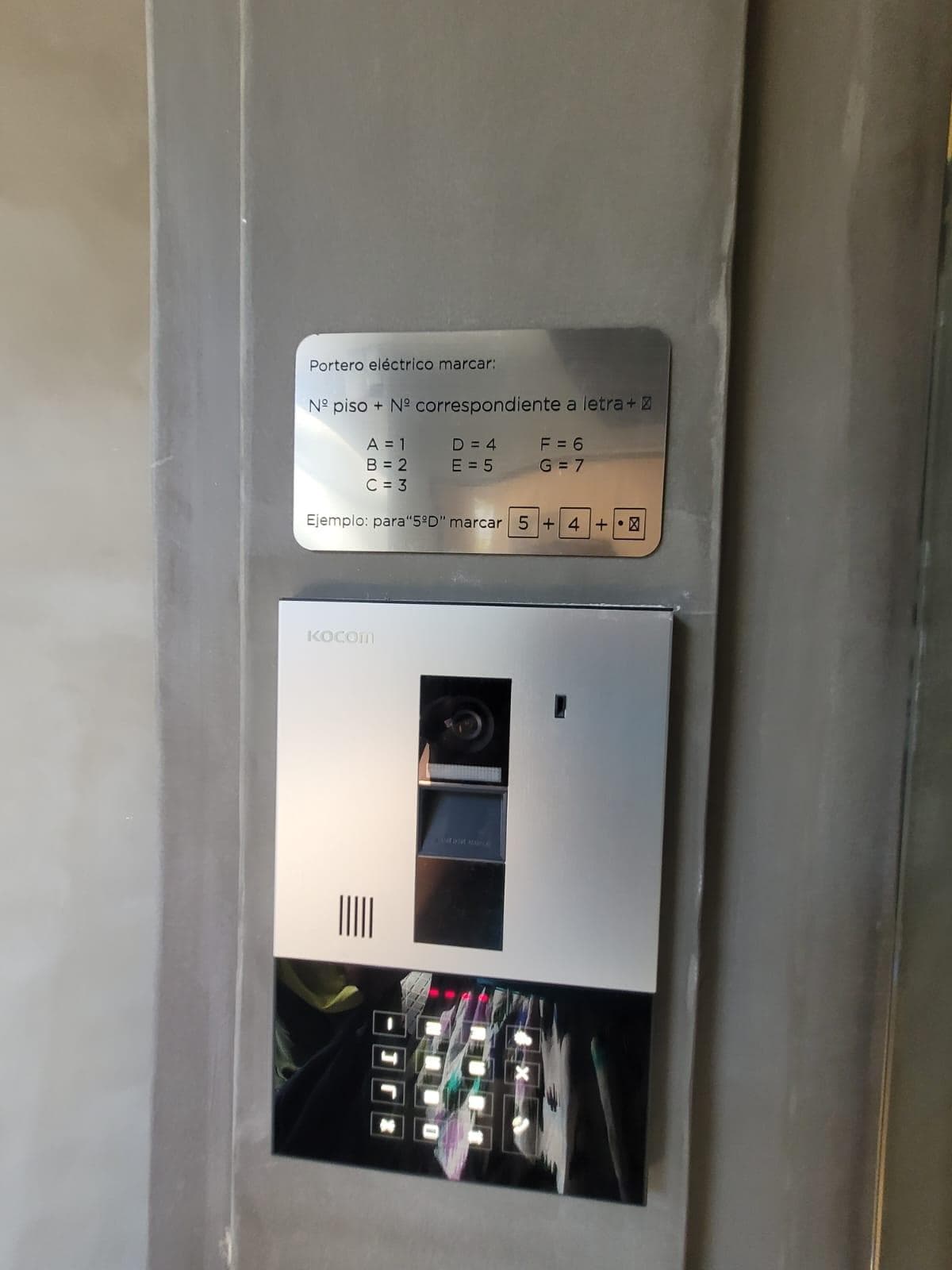 Panel de portero eléctrico con cámara y teclado para acceso.