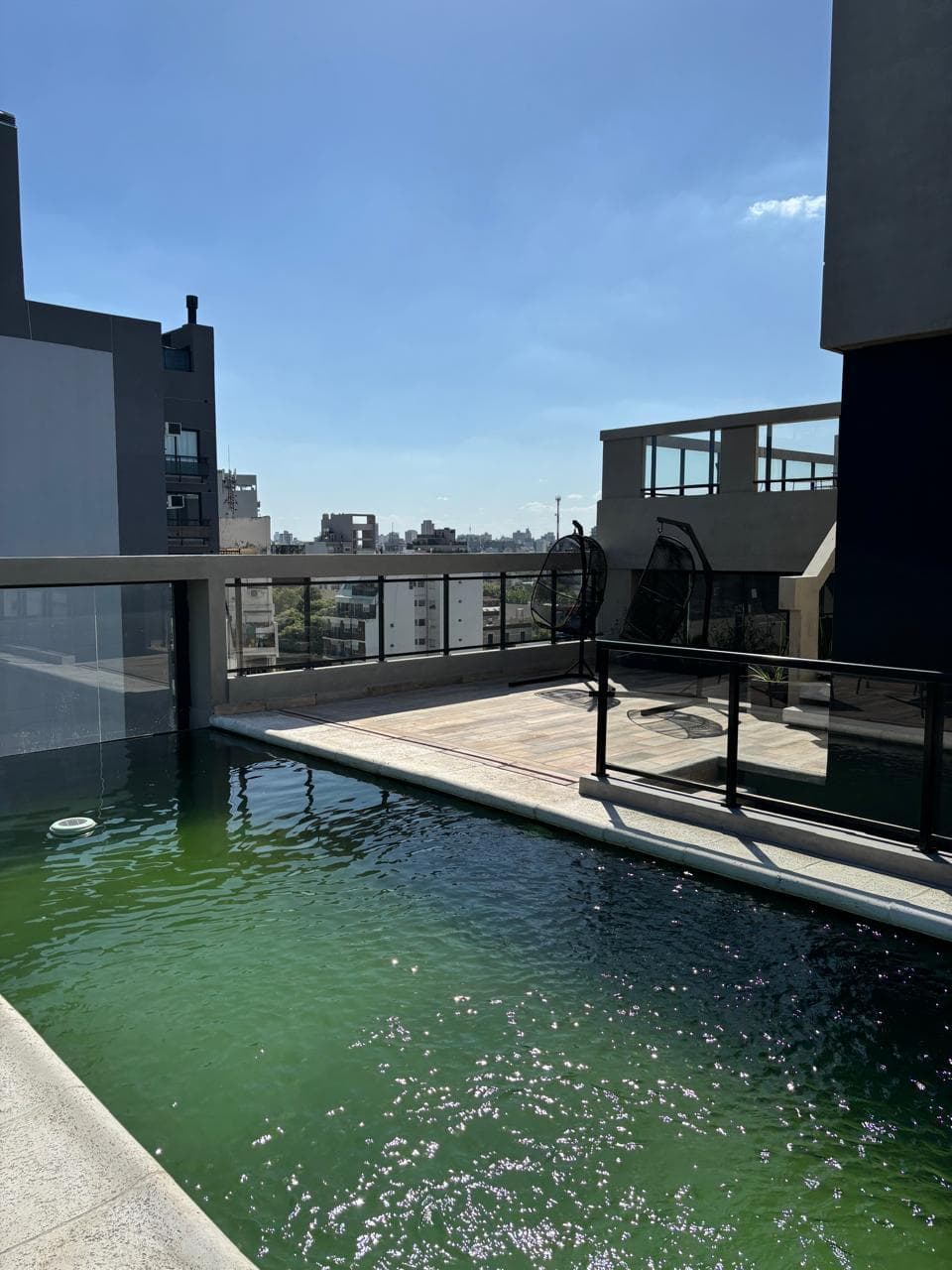 Pileta en la terraza del edificio con vista a la ciudad.