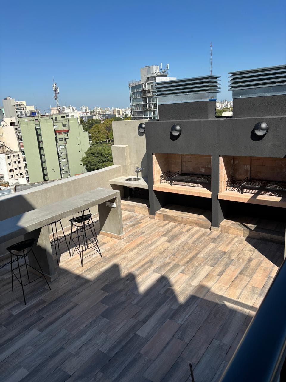Área de parrillas con barra y vista panorámica desde la terraza.