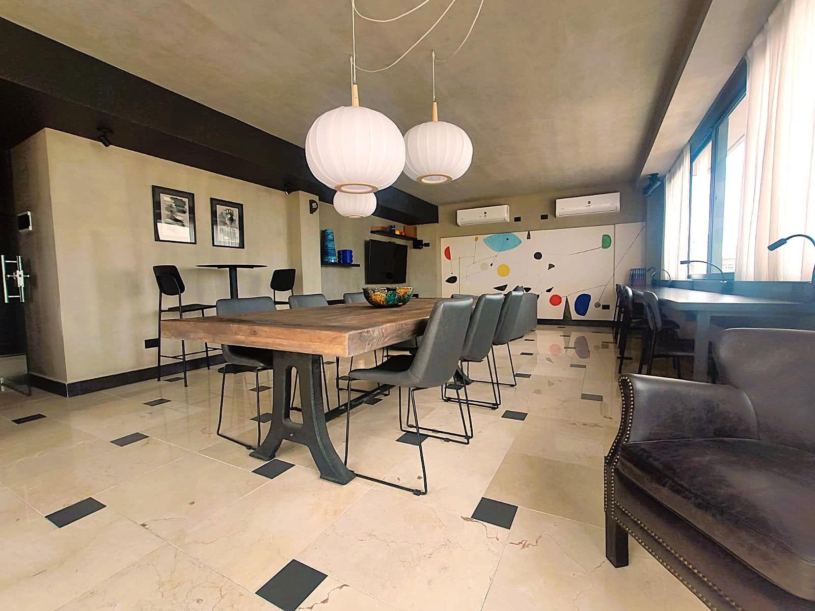 Salón espacioso con mesa grande y sillas, ideal para reuniones.