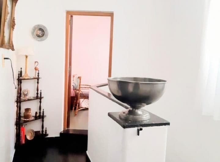 Pasillo con objeto decorativo y puerta abierta que muestra otro ambiente.