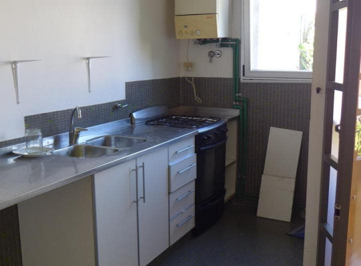 Cocina con mesada de acero inoxidable, bacha doble y anafe.