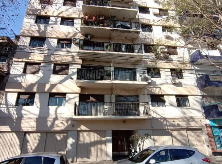 Fachada del edificio de departamentos con balcones y cocheras.