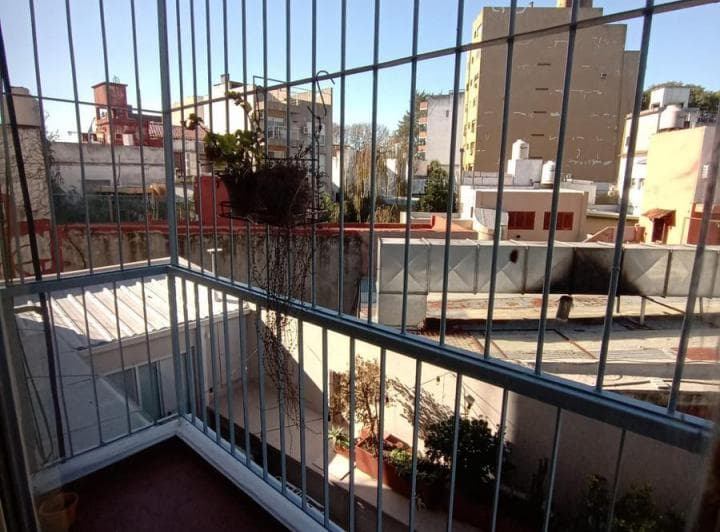 Balcón con rejas y vista a los edificios de la ciudad.
