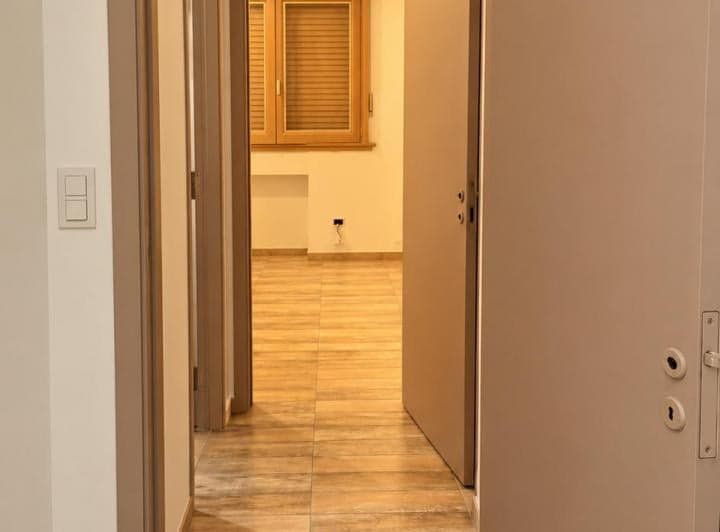 Pasillo con piso símil madera, puertas abiertas a ambientes.