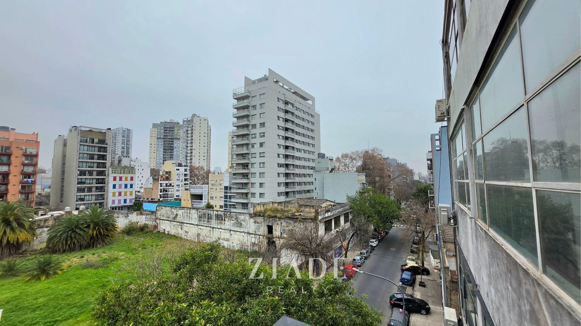Vista urbana desde el balcón, mostrando edificios y paisaje de la ciudad.