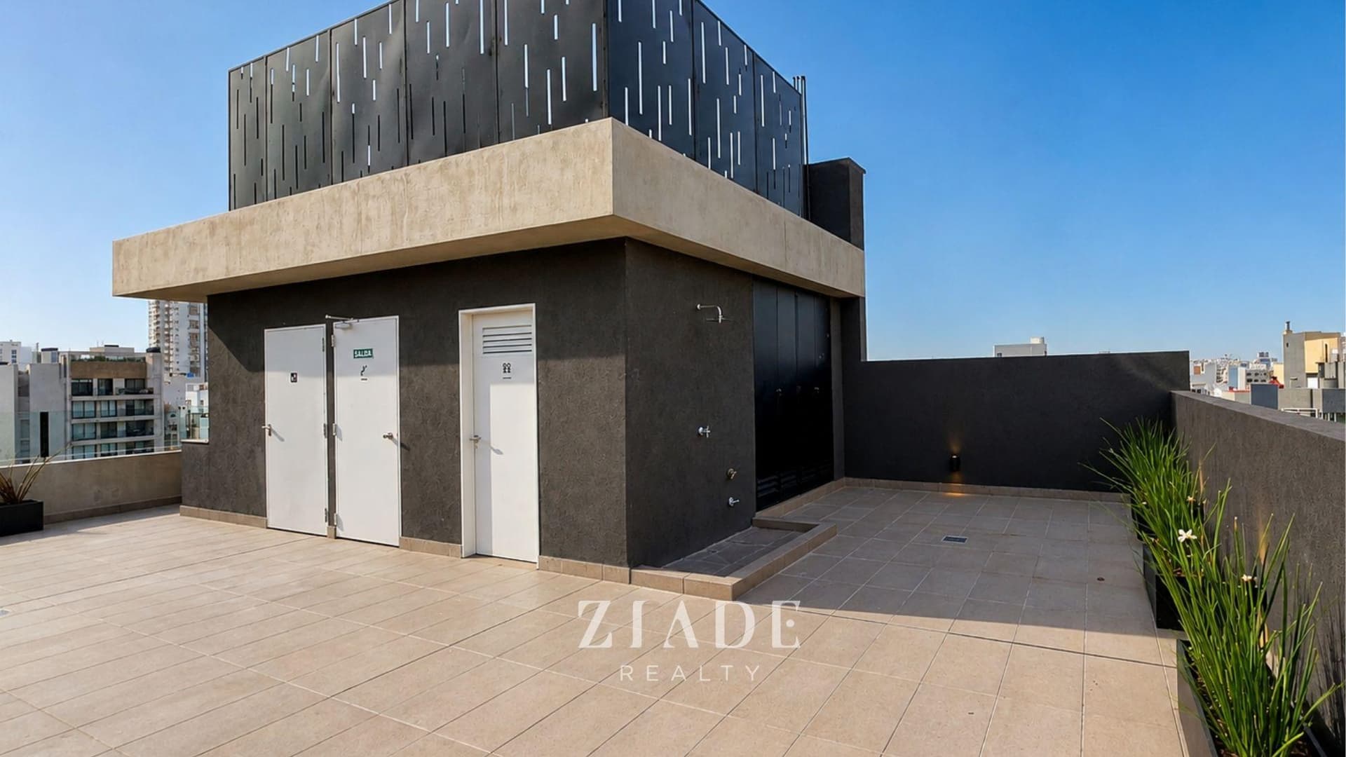Terraza común en el edificio, con piso de cerámica y cielo azul.