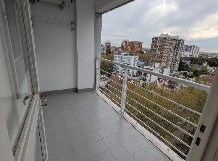 Balcón con baranda blanca y vista a la ciudad.